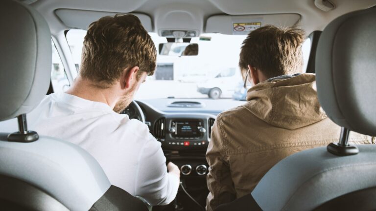 two men sitting inside vehicle