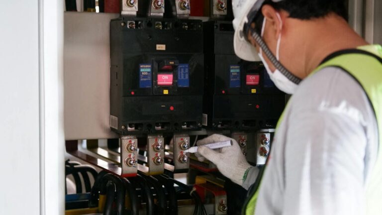 Close-Up Photo of a Man Checking a Power Voltage